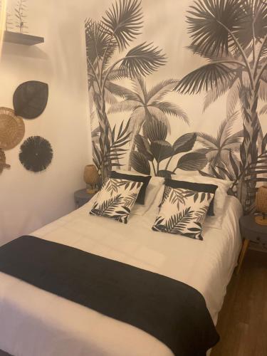 une chambre avec un lit avec des oreillers noirs et blancs dans l'établissement Appartement près de la Citadelle, à Blaye