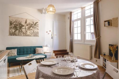 un salon avec une table et un canapé bleu dans l'établissement L'Appart du Palais - Hypercentre au calme, à Bourg-en-Bresse