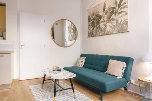 un salon avec un canapé vert et une table dans l'établissement L'Appart du Palais - Hypercentre au calme, à Bourg-en-Bresse