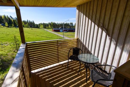 a porch with a table and chairs and a field at Knutes pensionat in Svansele