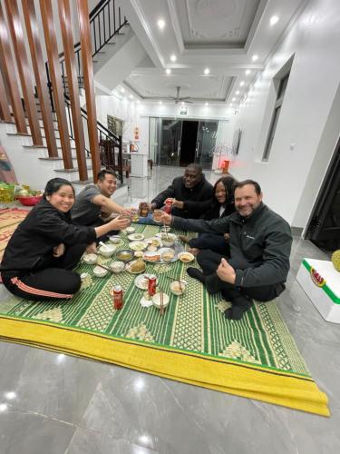 a group of people sitting around a table eating food at Tamcoc Motel in Văn Lâm