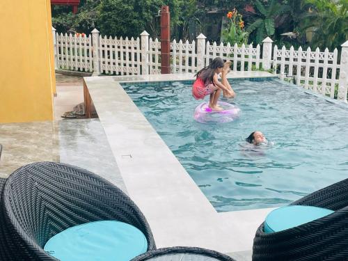 a girl riding on a ball in a pool with a man at Canal's Edge in Negombo
