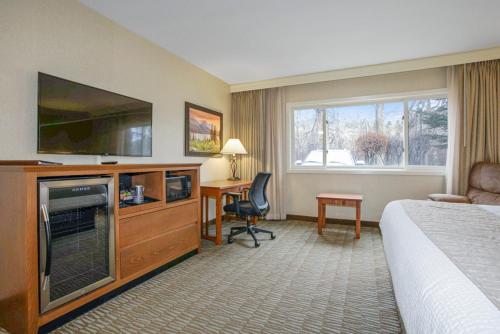 a hotel room with a bed and a flat screen tv at C'mon Inn Missoula in Missoula