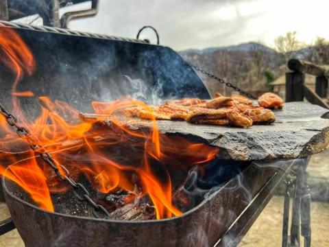 a grill with some food on it with flames at Complex Chalet -Turlashkata Kushta in Gabrovo