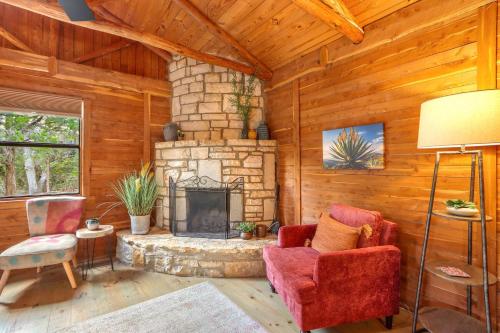 a living room with a stone fireplace in a log cabin at Sanderson at The Bend in Wimberley