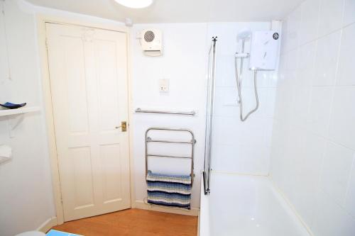 ein Badezimmer mit Handtuchhalter und Dusche in der Unterkunft Hafan Cottage in Caernarfon