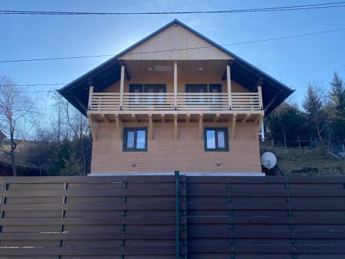 a large wooden house behind a wooden fence at Skh 3 in Praid