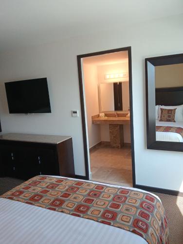 a hotel room with a bed and a mirror at Ankara Pedregal Centro de Convenciones in San Luis Potosí