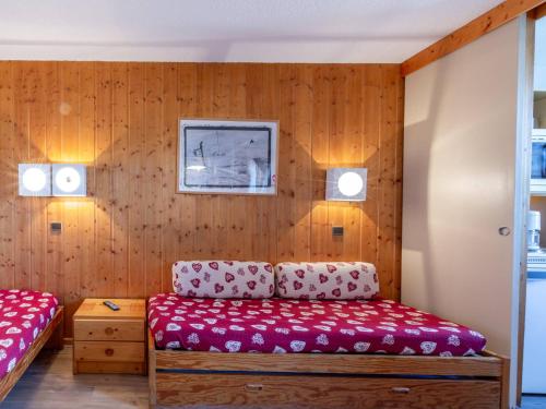 Cette chambre dispose de murs en bois, d'un canapé et de lumières. dans l'établissement Studio confortable pour 3 avec balcon et animaux acceptés à La Plagne - FR-1-353-9, à La Plagne