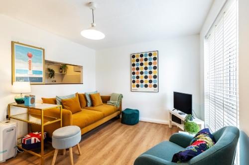 a living room with a couch and a tv at Cosy 1-Bed Flat by Central London in London