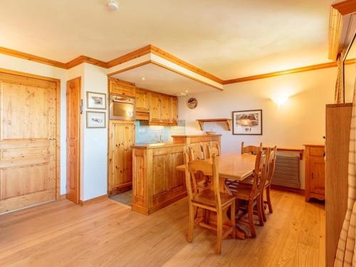 - une cuisine avec une table en bois et des placards en bois dans l'établissement Appartement cosy 3 pièces, piscine, sauna, hammam, à 100m des pistes, parking couvert inclus - FR-1-351-28, à La Plagne