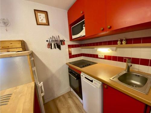 une petite cuisine avec un évier et une cuisinière dans l'établissement Appartement cosy 43m² avec balcon sud, parking couvert, proche commerces, animaux acceptés. - FR-1-351-51, à Plagne 1800