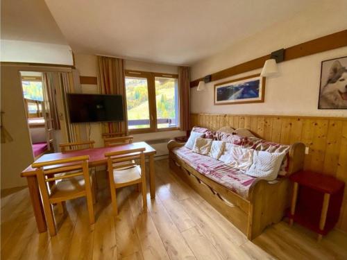 un salon avec un canapé et une table dans l'établissement Appartement cosy 43m² avec balcon sud, parking couvert, proche commerces, animaux acceptés. - FR-1-351-51, à Plagne 1800