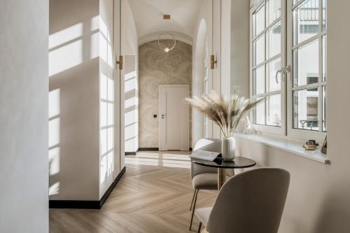 a living room with a table and chairs and windows at Millou - LoftAffair Collection in Kraków