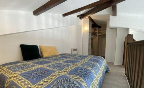 - une chambre dotée d'un lit avec une couverture bleue et jaune dans l'établissement Loft lumineux et calme - terrasse - piscine, à Antibes