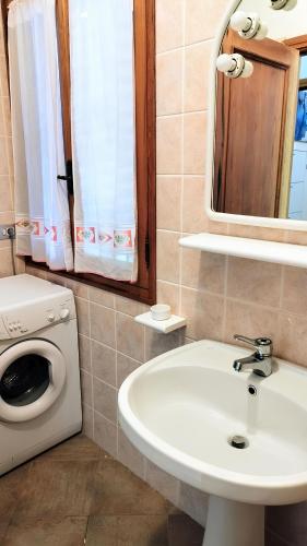 a bathroom with a sink and a washing machine at Villa Frantina in Quartu SantʼElena
