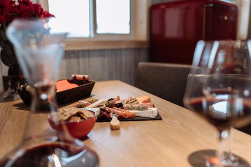 a table with a plate of food and two glasses of wine at Quiet Country Cabin in Waiparous Village