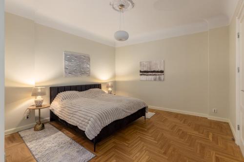 a bedroom with a bed and a table with a lamp at K1820 Family apartments in Rīga
