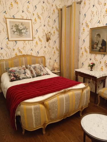 - une chambre avec un lit dans une pièce avec du papier peint dans l'établissement Chambre d'hôtes LA BELLE SAISON, à Villedômer