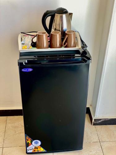 a tea kettle and cups on top of a refrigerator at Isis Pyramids and sphinx view in Cairo