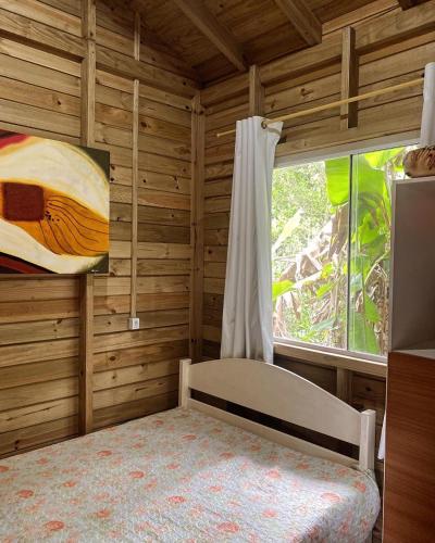 a bedroom with a bed and a window in a room at Paraíso do Rosa in Praia do Rosa