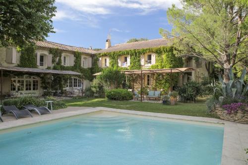 une grande piscine devant une maison dans l'établissement Logis Hôtel La Sommellerie, à Châteauneuf-du-Pape