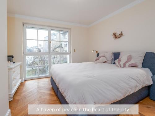 a bedroom with a large bed and a window at Pétrusse Élite Suites in Luxembourg