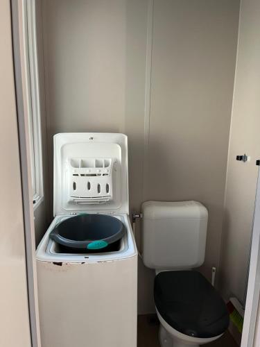 La petite salle de bains est pourvue de toilettes et d'un four micro-ondes. dans l'établissement Mobil Home 3 chambres dans camping 4 étoiles, à Vias