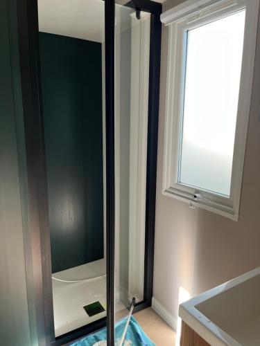d'une salle de bains avec un miroir et une fenêtre. dans l'établissement Mobil Home 3 chambres dans camping 4 étoiles, à Vias