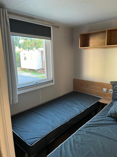 une petite chambre avec un lit et une fenêtre dans l'établissement Mobil Home 3 chambres dans camping 4 étoiles, à Vias