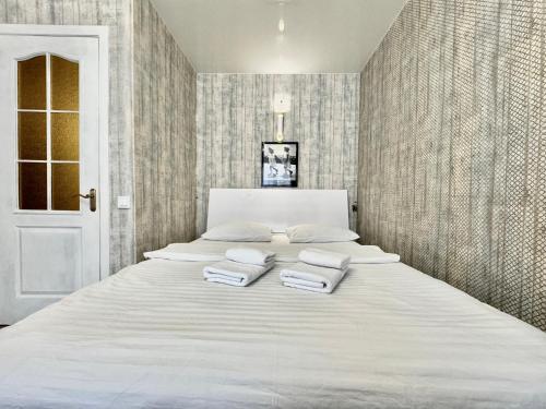 a bedroom with a large white bed with two pillows at ApartPoltava Смак Італії у самому центрі Полтави , білосніжна студія в новобудові, банківський чек in Poltava
