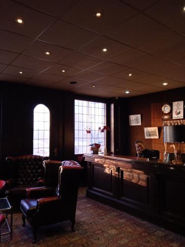 a waiting room with chairs and a bar in a building at Metropol Hotel in Calais