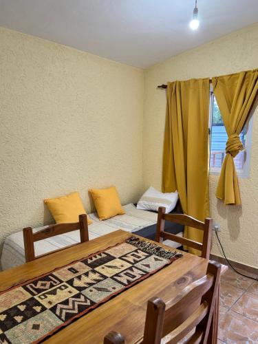a room with two beds and a table and a window at La casita de Oli in Tanti