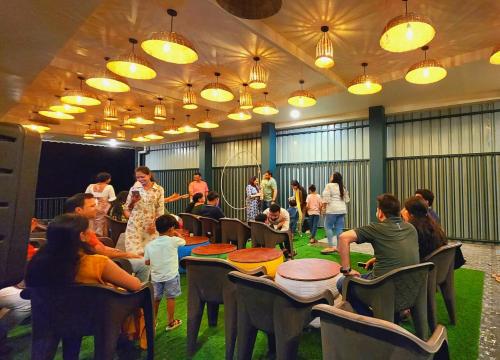 a group of people sitting around tables in a room at Tathastu Farms & Resort in Kota