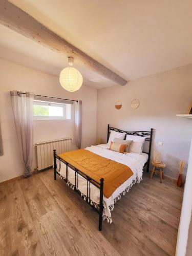 une chambre avec un grand lit avec un plancher en bois dans l'établissement Le petit Mazet, à Ménerbes