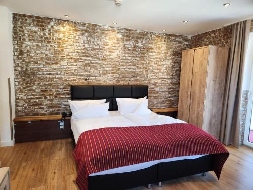 a bedroom with a bed and a brick wall at Hotel Almrausch in Bad Reichenhall