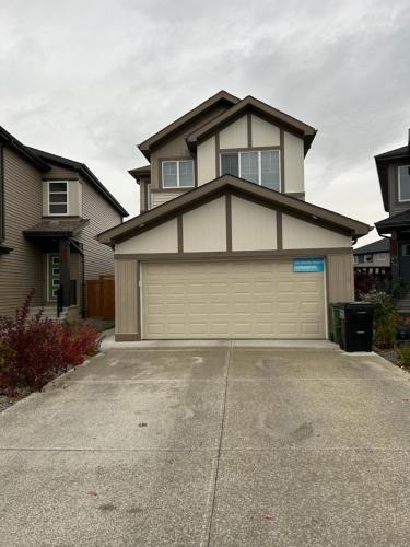 a large house with a garage in a driveway at Bedroom SW Edmonton HWY 2 near YEG in Edmonton