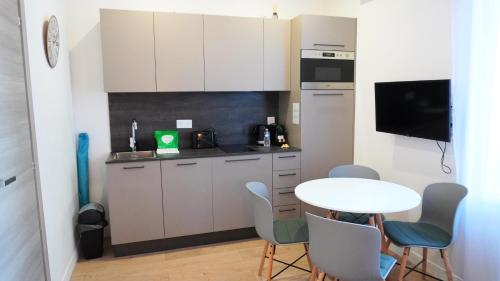 - une cuisine avec une table, une petite table et des chaises dans l'établissement Proche Carlton & Croisette, Appartement 101 - Palmazur Vacances, à Cannes