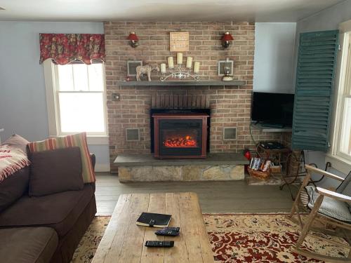 a living room with a fireplace and a couch at Yellow Sweetie at the Base of Stratton in Jamaica