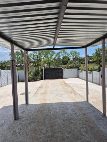 a large metal pavilion with a large driveway at Wattlewood Cabins in Piet Retief