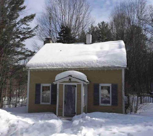 a small house with snow on the roof at Yellow Sweetie at the Base of Stratton in Jamaica