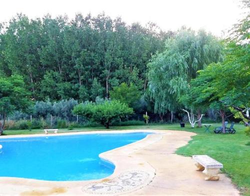 a swimming pool with a bench in a park at Los Jazmines in Benalúa de Guadix