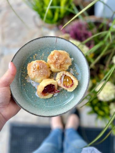 a person holding a plate of donuts in a bowl at Zagroda na Pacanach in Iwkowa