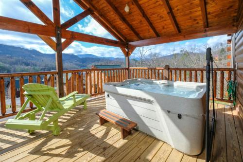 a hot tub on a deck with a rocking chair and a chair at Hot tub, pool table, and AMAZING VIEW! Gorgeous! in Gatlinburg