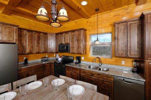 a kitchen with wooden cabinets and a table with chairs at Hot tub, pool table, and AMAZING VIEW! Gorgeous! in Gatlinburg