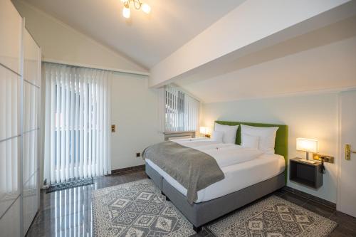 a bedroom with a bed and a large window at Chiemgauzeit Ferienwohnung - Chiemgau Karte in Inzell
