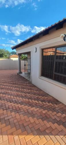 a house with a brick driveway in front of it at Gugulethu Villa in Rensburgdorp