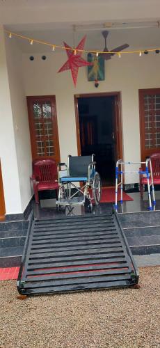 a room with chairs and a table and a wheelchair at Kuttickattil Gardens Homestay in Kottayam