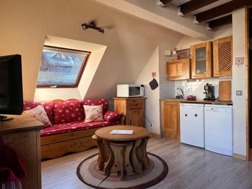 un salon avec un canapé rouge et une table dans l'établissement Ski in-ski out appartement in het centrum van Oz 3300, à Oz