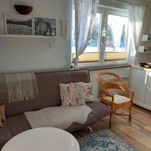 a living room with a couch and a chair at Domki Obłazówka nad Białką in Nowa Biała